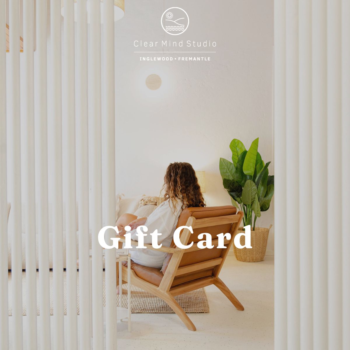 Custom gift card at clear mind studio. Woman sitting in a wooden chair in a minimalistic room with 'Clear Mind Studio' branding.